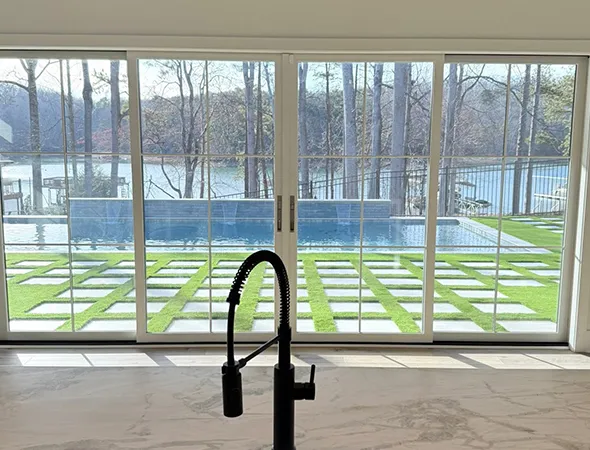 Close-up of soft synthetic turf beside a backyard swimming pool